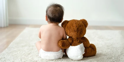Baby sitz mit Teddy am Boden