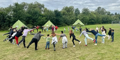 People stand in a circle and do exercises.